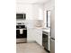 Bright white kitchen featuring stainless steel appliances, tile backsplash, and updated fixtures at 3147 W Phelps Rd, Phoenix, AZ 85053