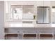 Bright kitchen features white cabinets, stainless steel appliances, subway tile backsplash, and a breakfast bar with seating at 3147 W Phelps Rd, Phoenix, AZ 85053