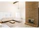 Cozy living room featuring a brick fireplace, a stylish light fixture, and neutral decor at 3147 W Phelps Rd, Phoenix, AZ 85053