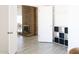 Open-concept living space with a brick fireplace and adjacent room with a built in storage unit at 3147 W Phelps Rd, Phoenix, AZ 85053