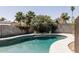 Backyard swimming pool is surrounded by a block wall, lush landscaping and mature palm trees at 3147 W Phelps Rd, Phoenix, AZ 85053