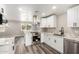 Modern kitchen features white cabinets, stainless steel appliances, granite countertops and grey wood floors at 3249 E Nisbet Rd, Phoenix, AZ 85032
