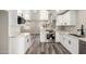 Bright kitchen featuring white cabinetry, stainless steel appliances, marble countertops, and wood floors at 3249 E Nisbet Rd, Phoenix, AZ 85032