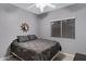 Bedroom with neutral walls, a dark gray bedding ensemble, and a ceiling fan, offering a comfortable retreat at 3336 E Thornton Ave, Gilbert, AZ 85297