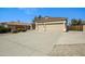 Spacious concrete driveway leading to a two-car garage, bordered by desert landscaping and a partial gate at 3336 E Thornton Ave, Gilbert, AZ 85297