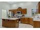 Kitchen with stainless steel appliances, wooden cabinets, and an island with light granite countertops at 3336 E Thornton Ave, Gilbert, AZ 85297