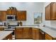 Kitchen showcasing wooden cabinets, stainless steel appliances, and light colored countertops at 3336 E Thornton Ave, Gilbert, AZ 85297