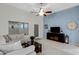 Living area featuring light colored walls, a comfortable couch, media center, and access to the backyard at 3336 E Thornton Ave, Gilbert, AZ 85297