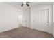 Bedroom featuring neutral carpet, ceiling fan, closet, and doorway at 3467 S Falcon Dr, Gilbert, AZ 85297