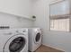 Well-lit laundry room featuring washer, dryer, and shelving at 3467 S Falcon Dr, Gilbert, AZ 85297