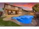 Inviting backyard with a sparkling pool, lush green lawn, and covered patio area at 45539 W Long Way, Maricopa, AZ 85139
