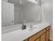 Bathroom with a large mirror, white countertop, and wooden cabinets at 45539 W Long Way, Maricopa, AZ 85139
