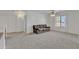 Spacious bonus room featuring a brown sofa and large window with natural light at 45539 W Long Way, Maricopa, AZ 85139
