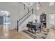 Bright dining room features staircase, chandelier, and backyard access at 45539 W Long Way, Maricopa, AZ 85139
