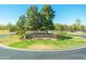 Maricopa Meadows entrance with lush landscaping, mature trees, and colorful flower beds creating an inviting atmosphere at 45539 W Long Way, Maricopa, AZ 85139