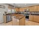 Well-appointed kitchen features granite countertops, island, and stainless appliances at 45539 W Long Way, Maricopa, AZ 85139