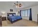 Relaxing main bedroom with a ceiling fan, window with natural light and wood-toned furniture at 45539 W Long Way, Maricopa, AZ 85139