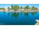 A picturesque pond with a gentle waterfall, surrounded by lush greenery and mature trees, creating a serene community space at 45539 W Long Way, Maricopa, AZ 85139