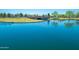 A tranquil lake with a bridge and lush green surroundings, offering a peaceful retreat within the community at 45539 W Long Way, Maricopa, AZ 85139