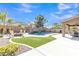 A stunning pool features a rock waterfall, surrounded by artificial turf and a spacious patio for outdoor enjoyment at 45539 W Long Way, Maricopa, AZ 85139