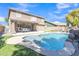 A beautiful backyard pool with rock waterfall feature and ample patio space for outdoor entertaining on a sunny day at 45539 W Long Way, Maricopa, AZ 85139