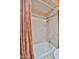Close-up of a bathtub with orange curtain and mosaic tile in a full bathroom at 4705 E Winston Dr, Phoenix, AZ 85044