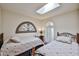 Bright bedroom with twin beds, skylight, and decorative wall art at 4705 E Winston Dr, Phoenix, AZ 85044