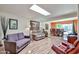 Open concept living room with skylight, wood floors, and view to the dining room at 4705 E Winston Dr, Phoenix, AZ 85044