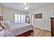 Comfortable main bedroom featuring wood floors, ceiling fan, sunny windows, and ensuite bath access at 4705 E Winston Dr, Phoenix, AZ 85044