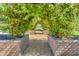Enchanting walkway through a lush trellis tunnel with greenery, stone planters and decorative gravel flooring at 4832 S Ferric --, Mesa, AZ 85212