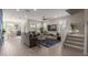 Open-concept living room featuring a large TV, modern furnishings, and a staircase leading to the upper level at 4832 S Ferric --, Mesa, AZ 85212