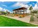 Inviting community patio area with modern pergola, lush landscaping, and comfortable Adirondack chairs at 4832 S Ferric --, Mesa, AZ 85212