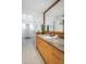 Bathroom featuring granite countertops, wood cabinets, and large mirror at 5211 N 24Th St # 104, Phoenix, AZ 85016