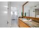 Bathroom featuring granite countertops, wood cabinets, and large mirror at 5211 N 24Th St # 104, Phoenix, AZ 85016
