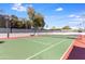 Green and red outdoor tennis court surrounded by green trees and under a blue sky at 5211 N 24Th St # 104, Phoenix, AZ 85016