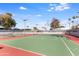 An empty tennis court featuring a two-tone color and tall, surrounding trees at 5211 N 24Th St # 104, Phoenix, AZ 85016