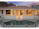 Back of desert home with a sparkling pool, columns and lights, offering a serene escape with mountain views at 6602 N Arizona Biltmore Cir, Phoenix, AZ 85016