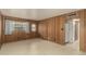 Cozy living room with warm wood paneled walls and bright natural light from two windows at 7844 N 17Th Ave, Phoenix, AZ 85021