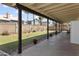 Back patio looking onto a large backyard featuring green grass, block wall, and desert landscaping at 8354 W Surrey Ave, Peoria, AZ 85381