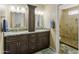 Bathroom with double sinks, granite countertops, and a tiled walk-in shower with glass doors at 8354 W Surrey Ave, Peoria, AZ 85381