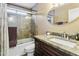 Bathroom featuring a shower over bath with glass doors, round mirror, and modern vanity at 8354 W Surrey Ave, Peoria, AZ 85381