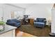 Cozy living room featuring comfortable blue seating, a wooden desk, and bright natural light through window at 8354 W Surrey Ave, Peoria, AZ 85381