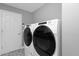 Laundry Room showing modern washer and dryer, and door with custom tile work at 9422 E Southwind Ln, Scottsdale, AZ 85262