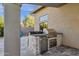 An outdoor kitchen with granite countertop and stainless steel appliances at 9422 E Southwind Ln, Scottsdale, AZ 85262