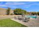 Backyard with a swimming pool, seating area and fire pit under a blue sky at 9422 E Southwind Ln, Scottsdale, AZ 85262