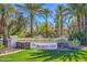 Landscaped entrance to The Racquet Club community with lush grass and mature palm trees at 9705 E Mountain View Rd # 1064, Scottsdale, AZ 85258