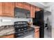 The kitchen features wooden cabinetry, black appliances, and granite countertops at 9705 E Mountain View Rd # 1064, Scottsdale, AZ 85258