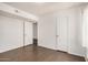 Bright bedroom featuring wood floors, fresh white paint, and closet with bi-fold doors at 10610 S 48Th St # 1068, Phoenix, AZ 85044