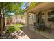 Private backyard featuring a covered patio, artificial grass, and shade trees, ideal for outdoor enjoyment at 12030 W Polk St, Avondale, AZ 85323