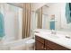 Well lit bathroom featuring a shower-tub combo, vanity, and decorative wallpaper at 12030 W Polk St, Avondale, AZ 85323
